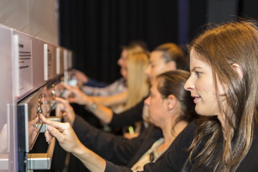 Guests test out Bosch's new circular dial to navigate through the ovens' menus.